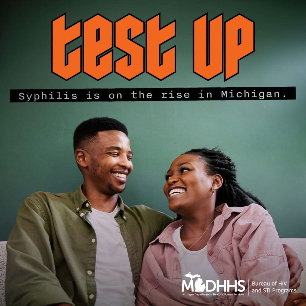 A couple sitting down smiling at each other with caption in picture test up, syphilis is on the rise in michigan.