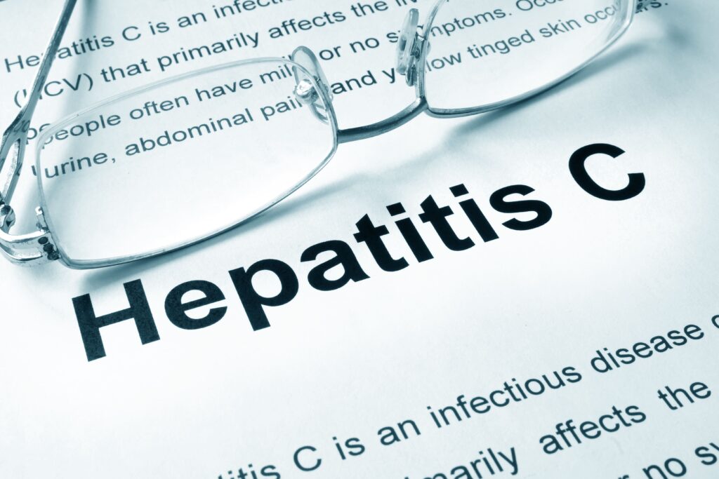 Healthcare provider holding a test tube labeled “Hepatitis C” to raise awareness about screening and treatment.