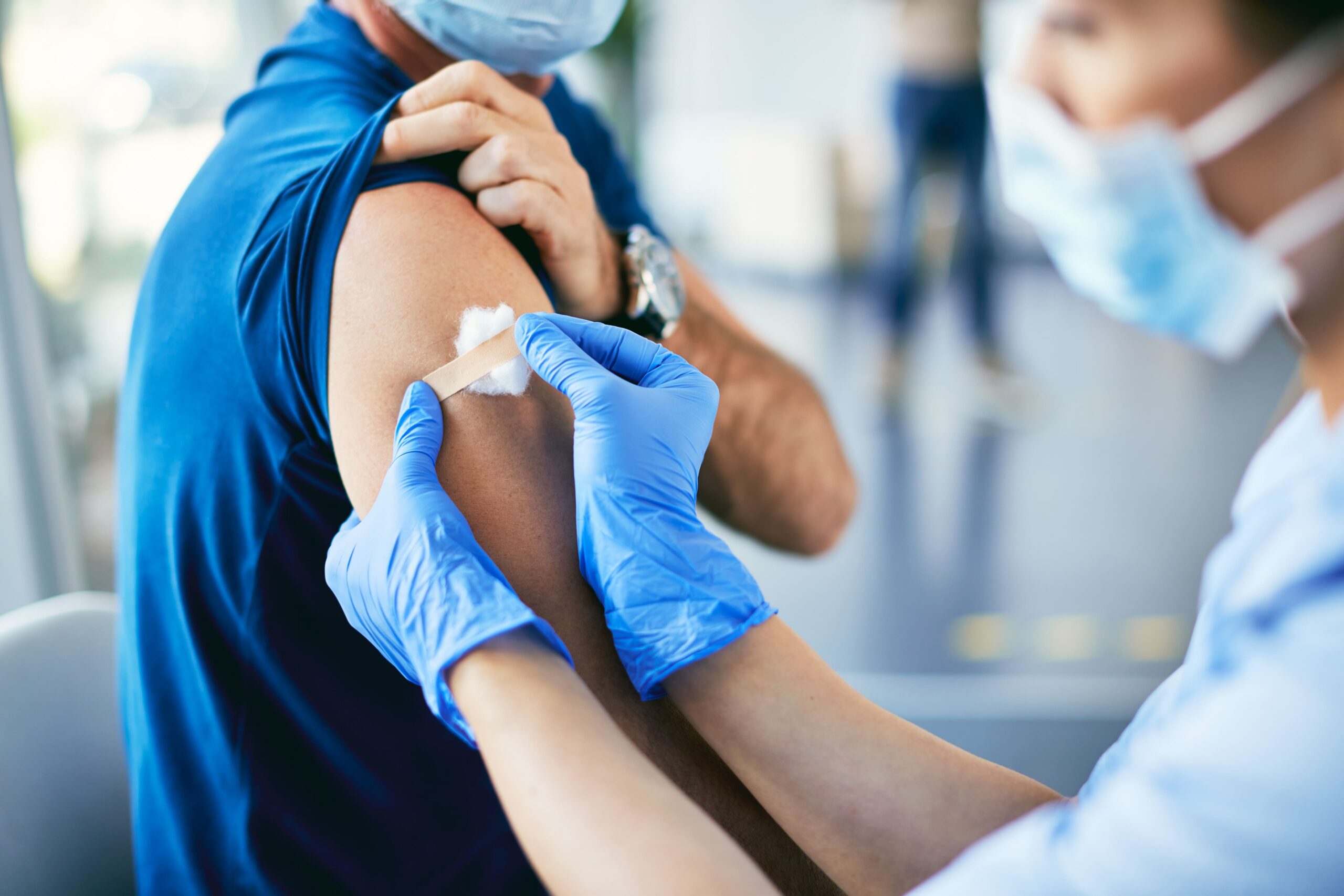 An adult receiving an immunization from a healthcare professional.