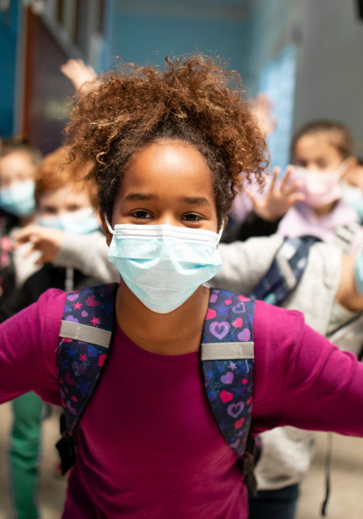 Group of school children wearing face masks in education center during Covid-19 pandemic.