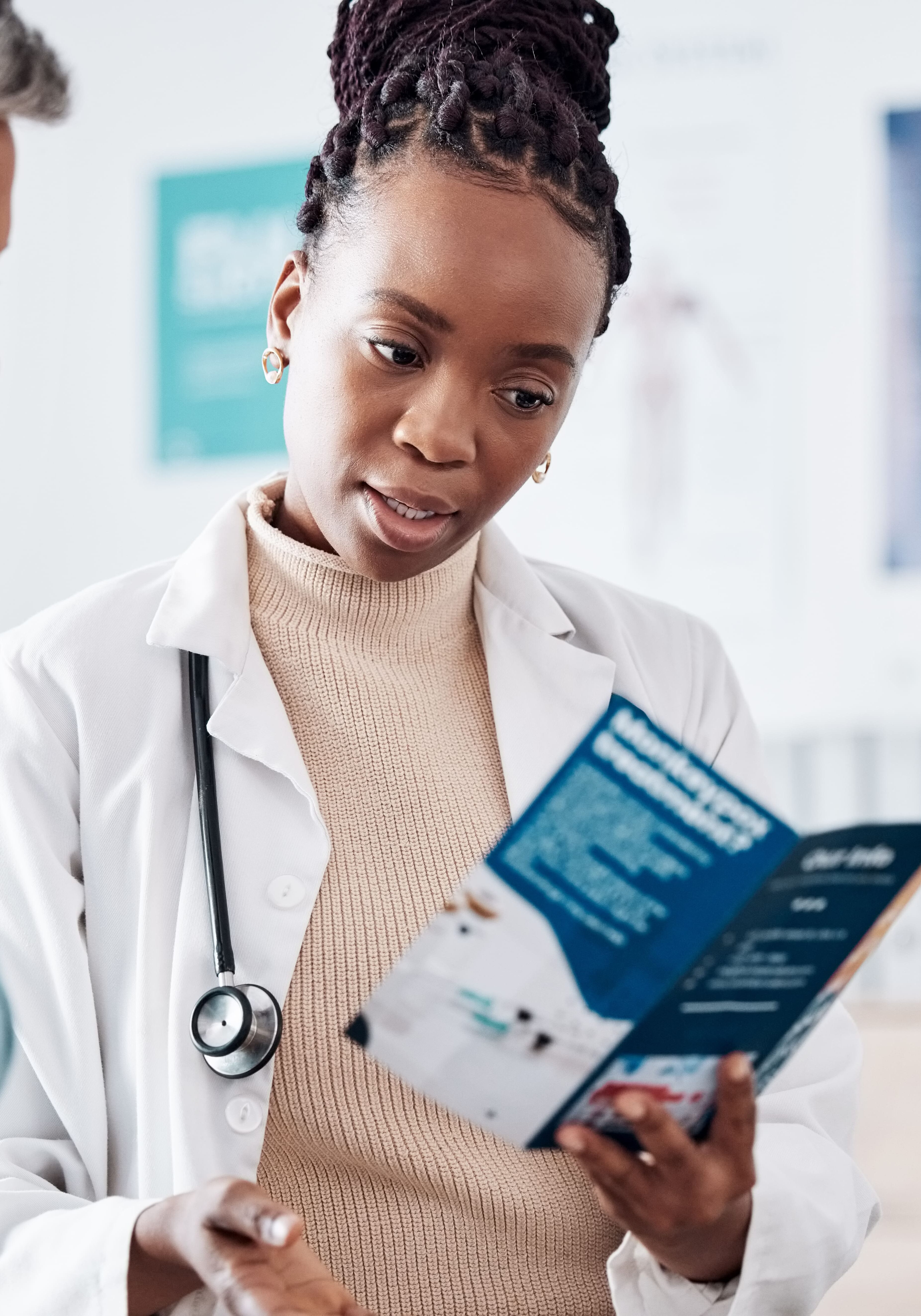 Doctor looking at brochure with patient in exam room